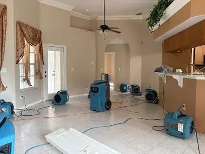 Air movers and dehumidifiers drying a tile-floored home in Naples, FL
